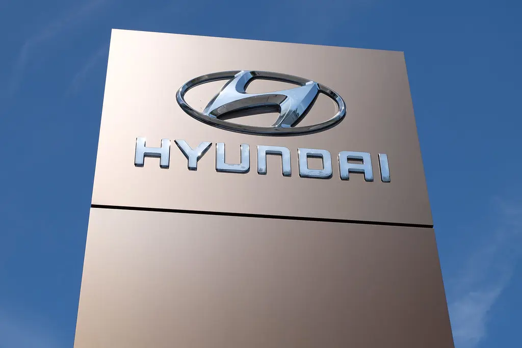 Логотип HYUNDAI на фоні різних типів батарейок, включаючи лужні та акумуляторні моделі.